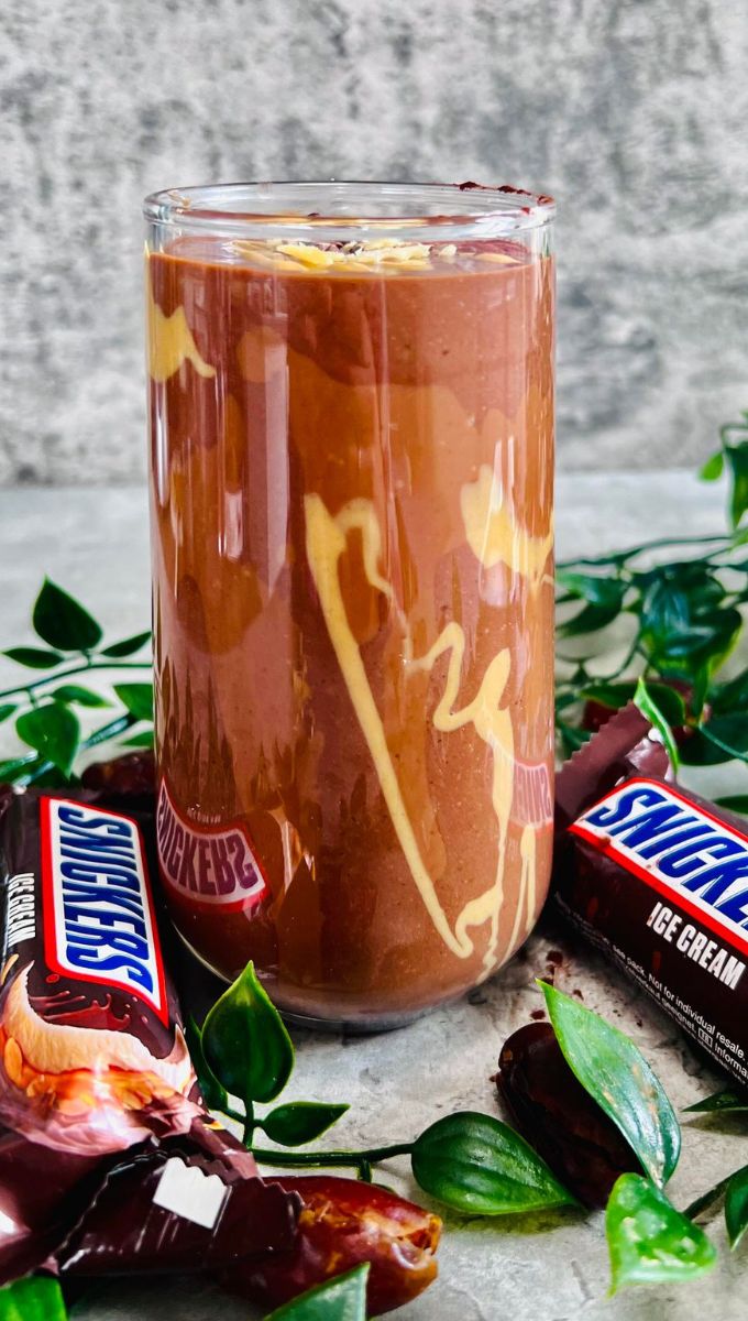 Healthy Snickers Smoothie served in a tall thin glass cup
