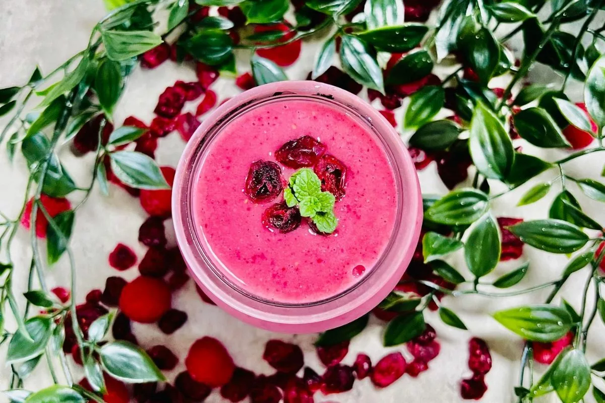 cranberry smoothie topped with fresh mint and dried cranberries
