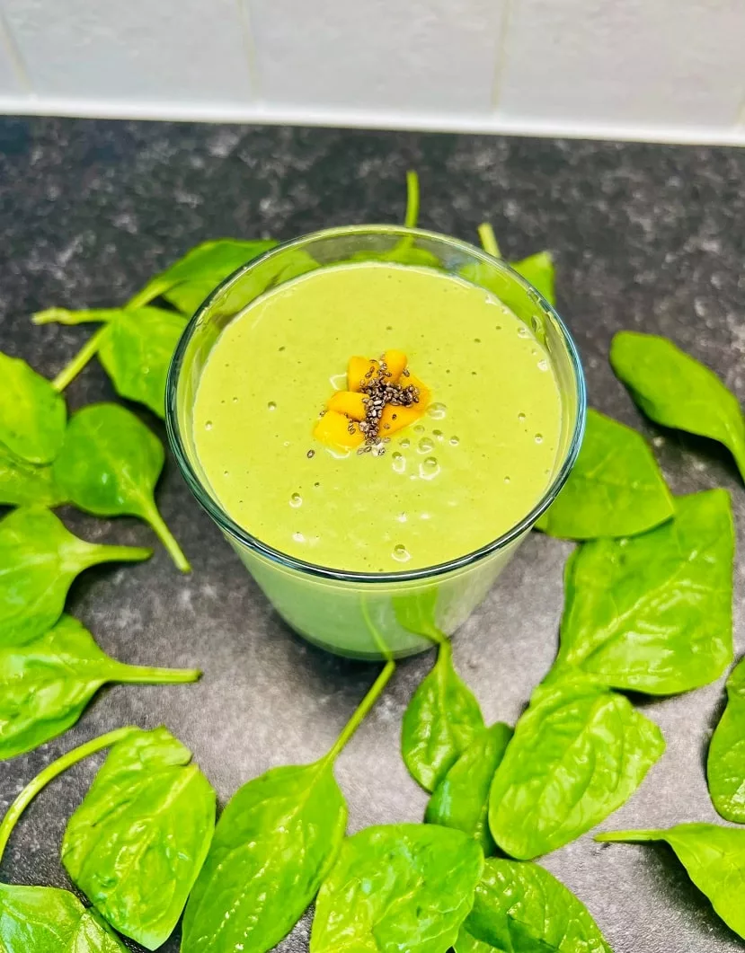 Matcha Mango Smoothie served in a glass cup topped with chia seeds and mango chunks