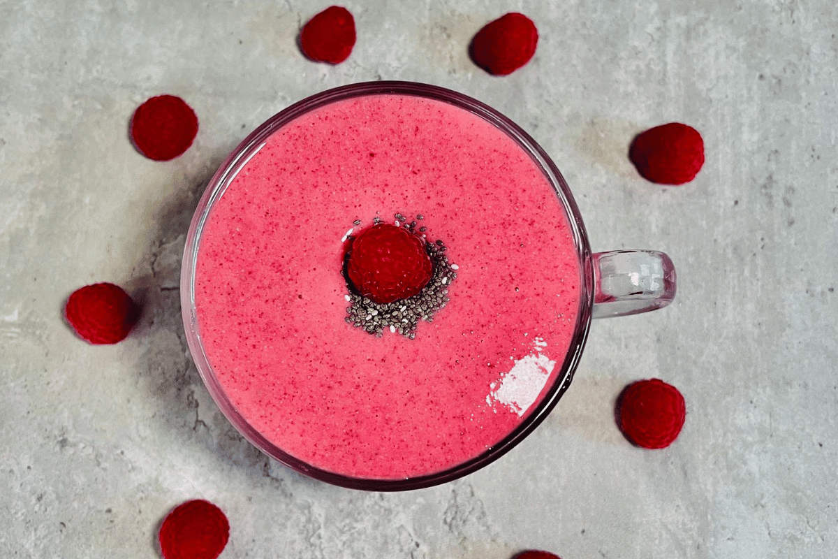 Apple Raspberry Smoothie surrounded by raspberries