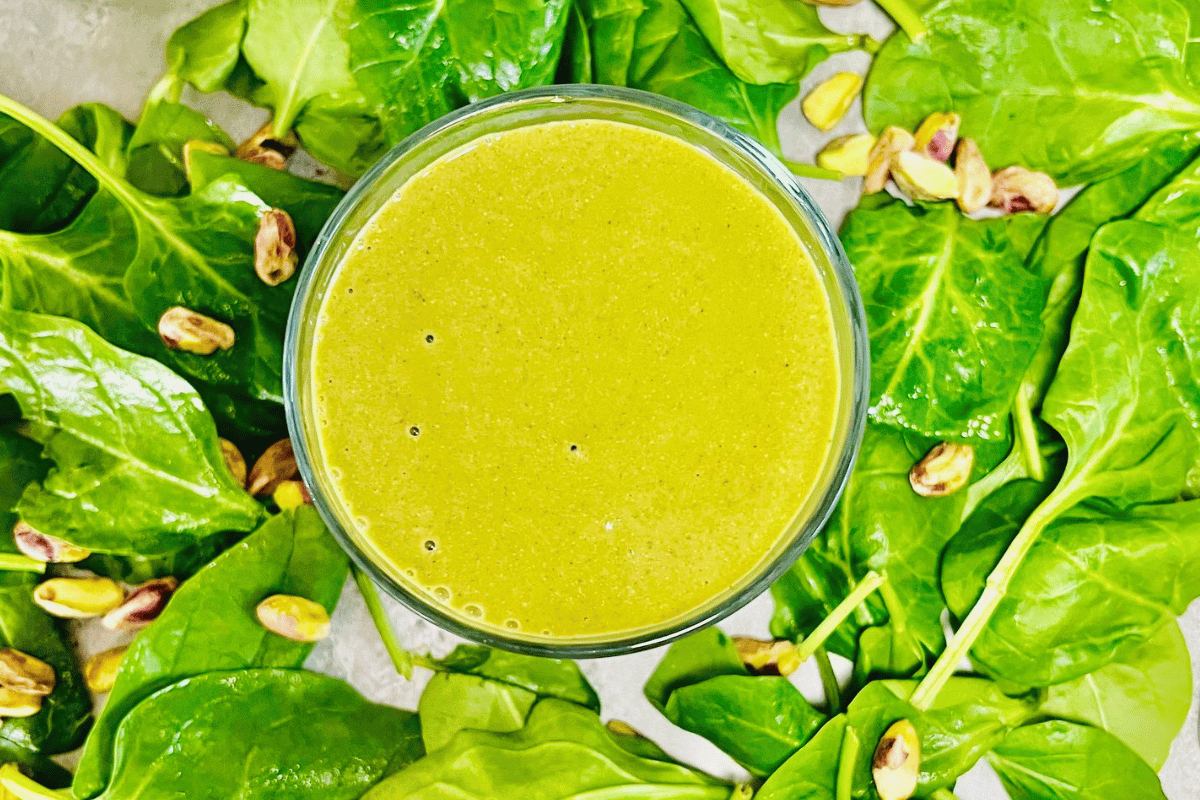 smoothie-surrounded-by-fresh-spinach-and-pistachio-nuts