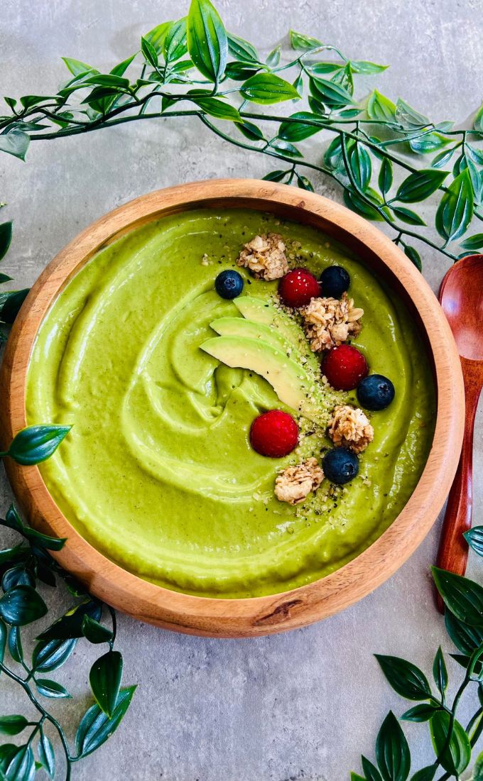 Detox Green Smoothie Bowl served in a wooden bowl topped with berries and granola