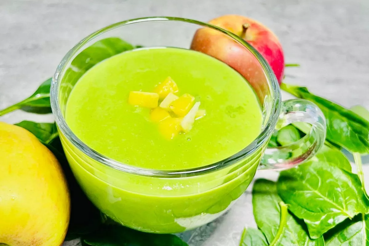 a side shot of a green smoothie made with spinach apple and mango