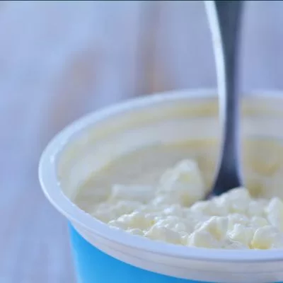 a container of cottage cheese with a spoon in it
