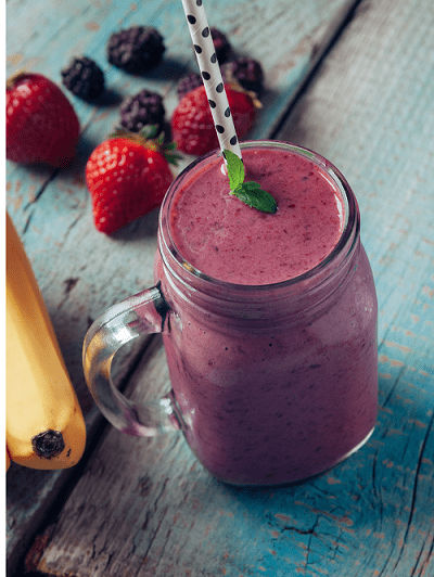 smoothie with banana and berries next to it