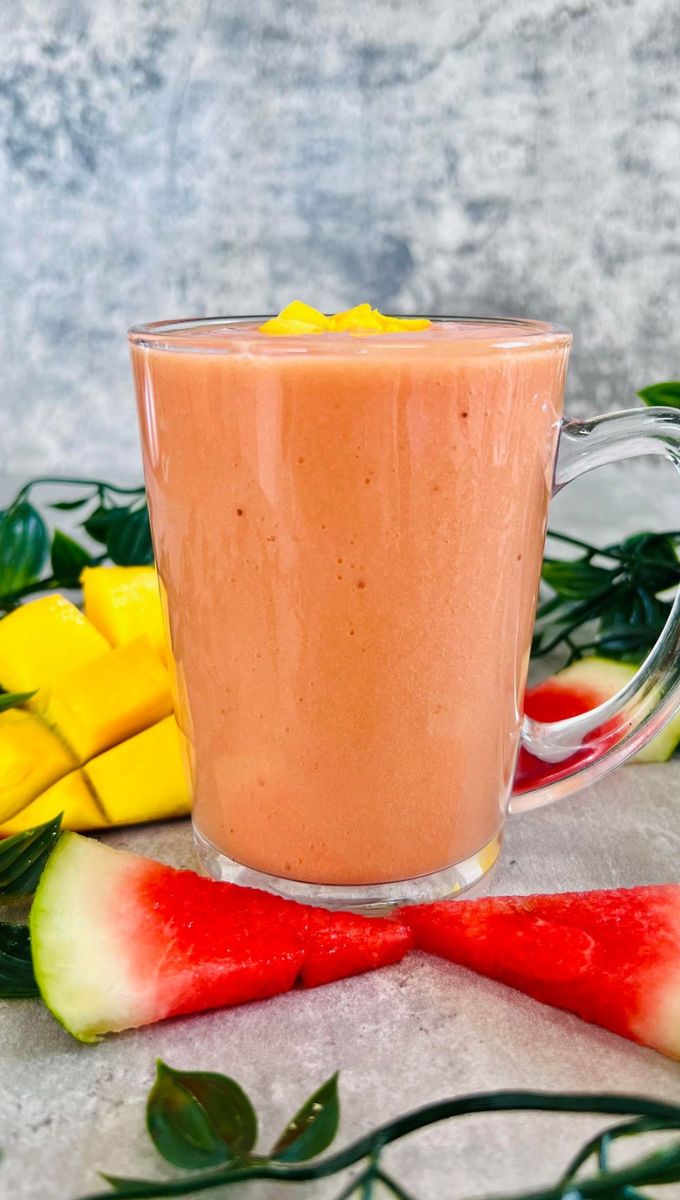 Mango Watermelon Smoothie surrounded by slices of watermelon and fresh mango