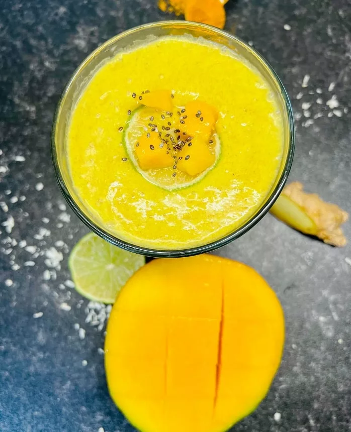 Smoothie with turmeric and mango around the glass