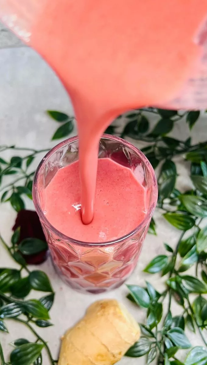 Beetroot Pineapple Ginger Smoothie being poured into a glass cup