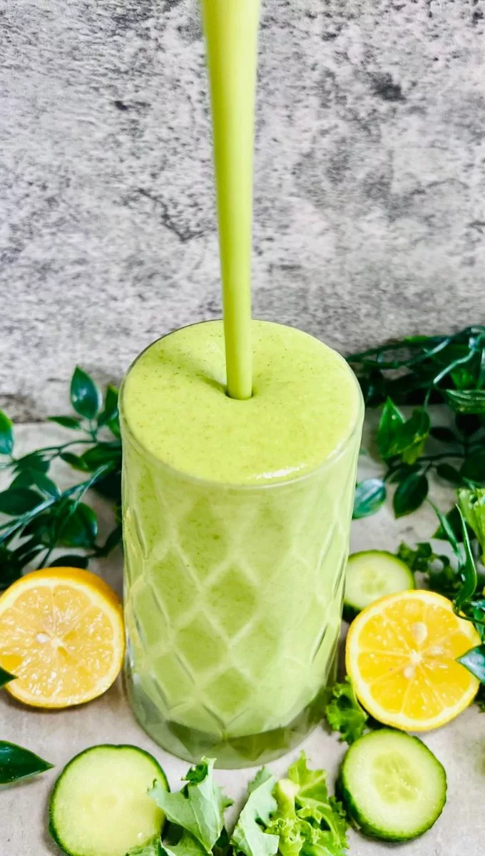 Cucumber Smoothie For Weight Loss being poured into a glass cup from a blender jug