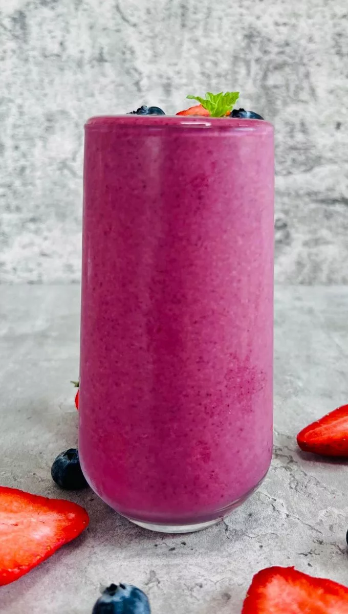 Strawberry Banana Blueberry Smoothie served in a tall thin glass cup