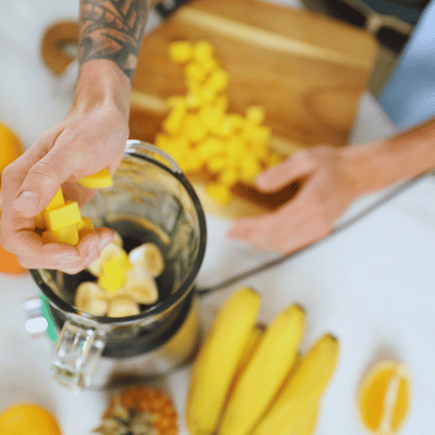 adding mango to a blender