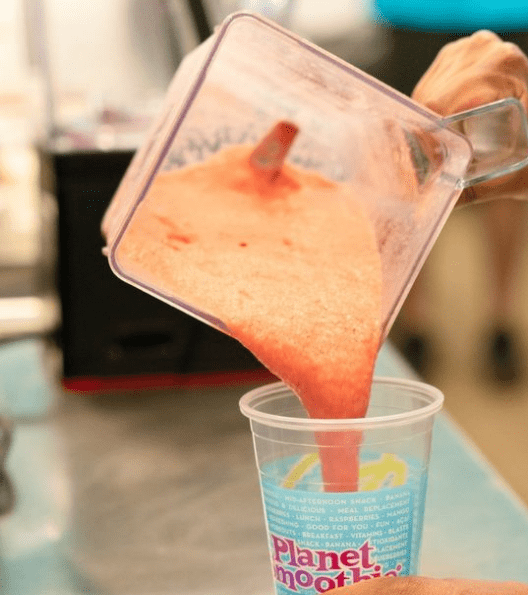Smoothie from a blender being poured into a cup