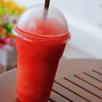 red smoothie in a plastic cup