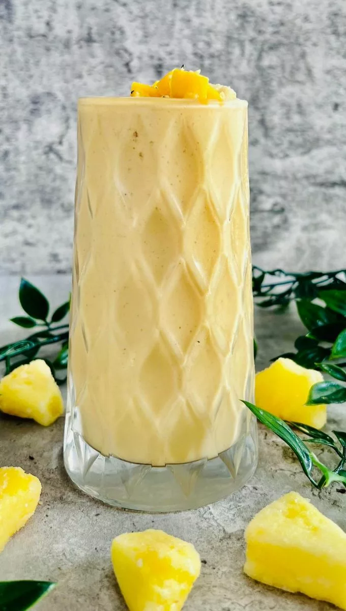 Banana Pineapple Mango Smoothie served in a tall thick glass cup