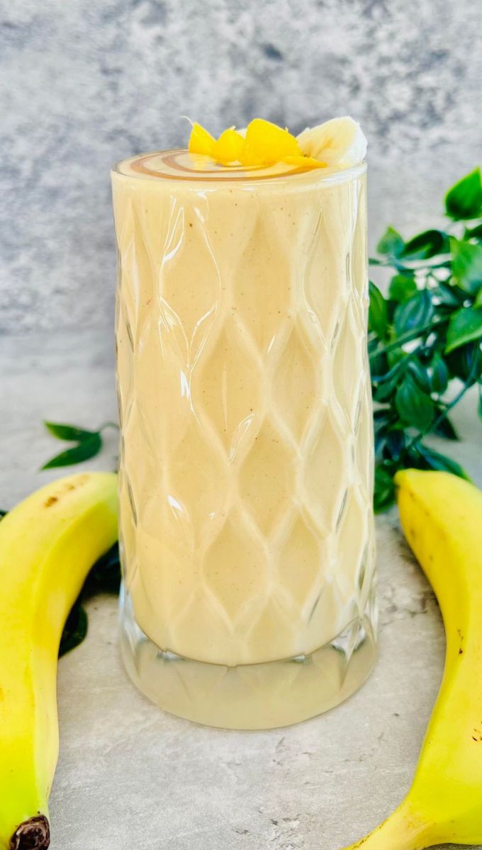 Mango Banana Smoothie served in a tall thick glass cup