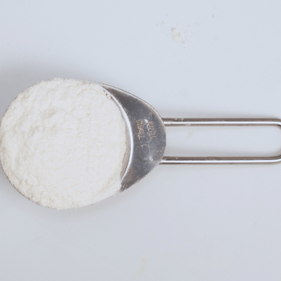 metal tablespoon on a flat surface filled with xanthan gum powder