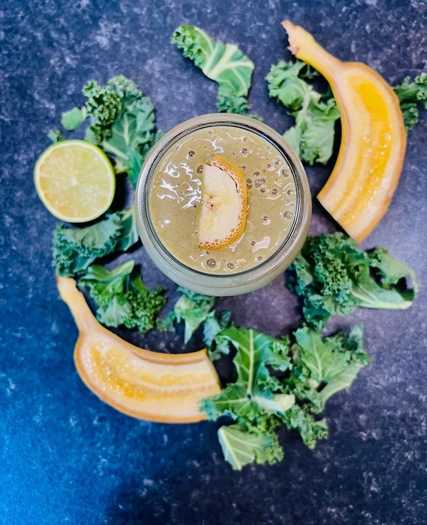 Banana Detox Smoothie with sliced banana and kale next to the cup