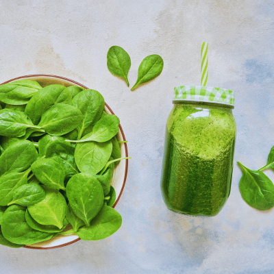 spinach with a green smoothie next to it