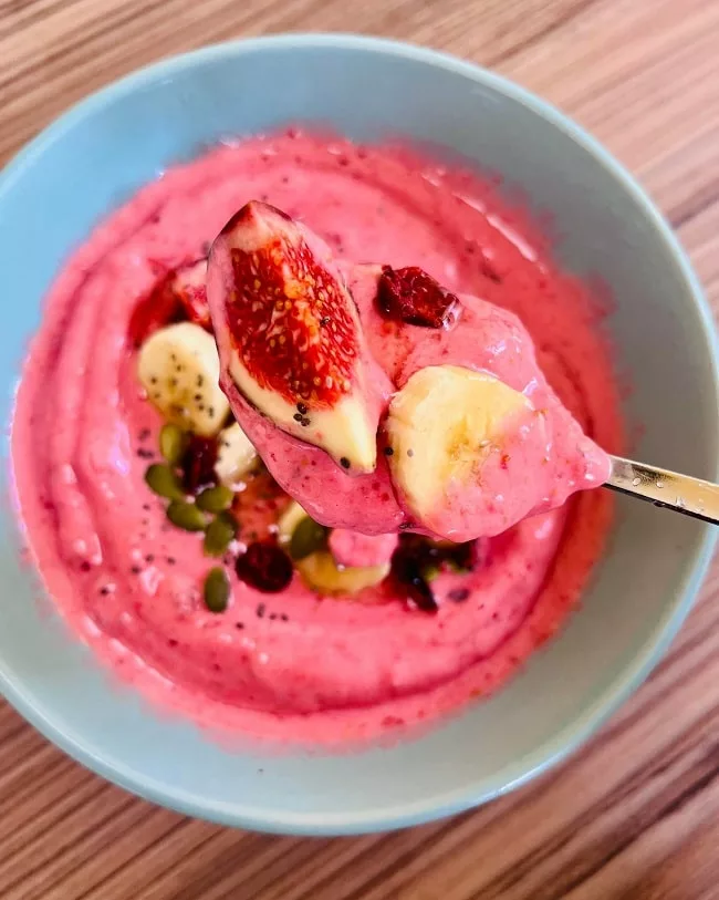 pink smoothie bowl with figs and berries