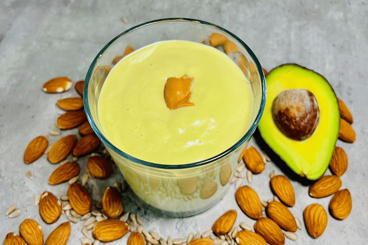 avocado smoothie surrounded by almonds