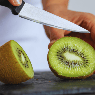 man slicing kiwi