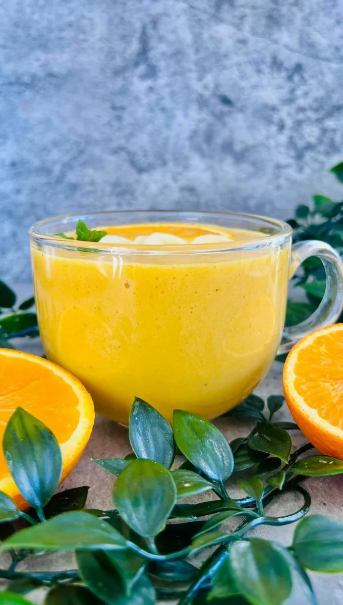 orange smoothie in a round glass cup