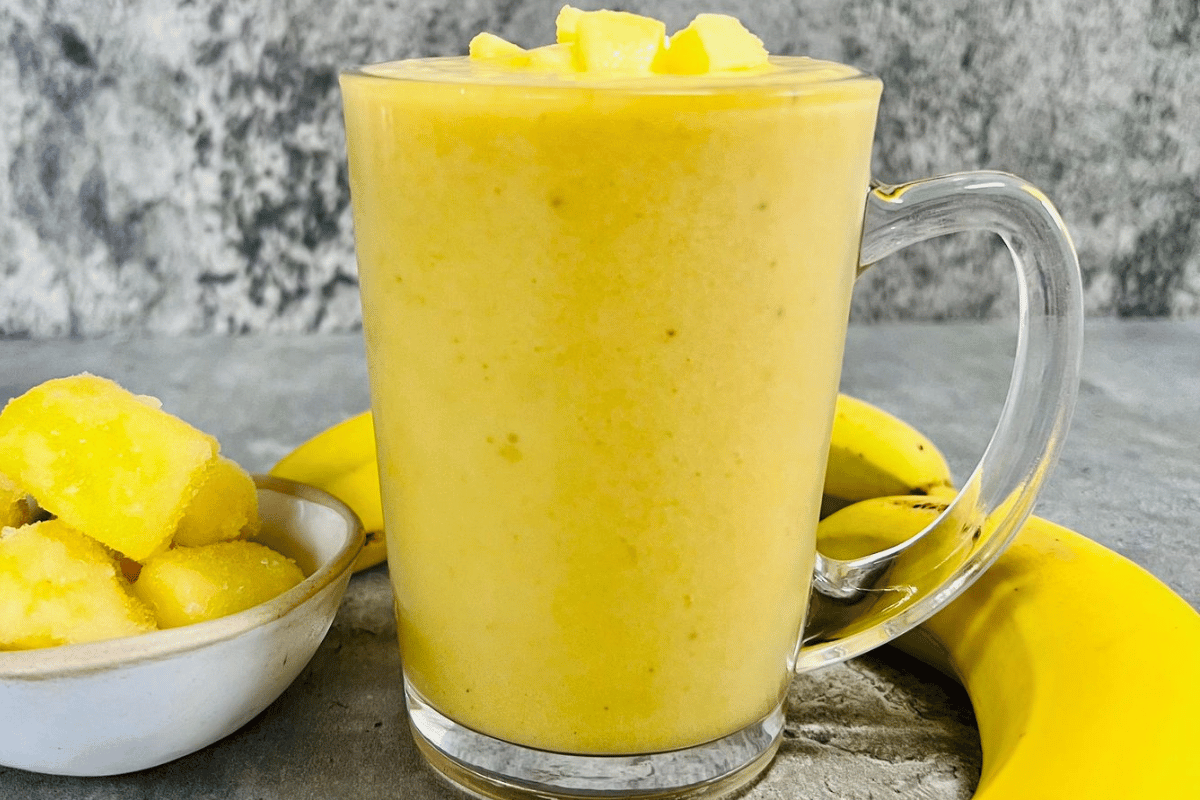 Pineapple Smoothie served in a tall glass cup topped with pineapple slices