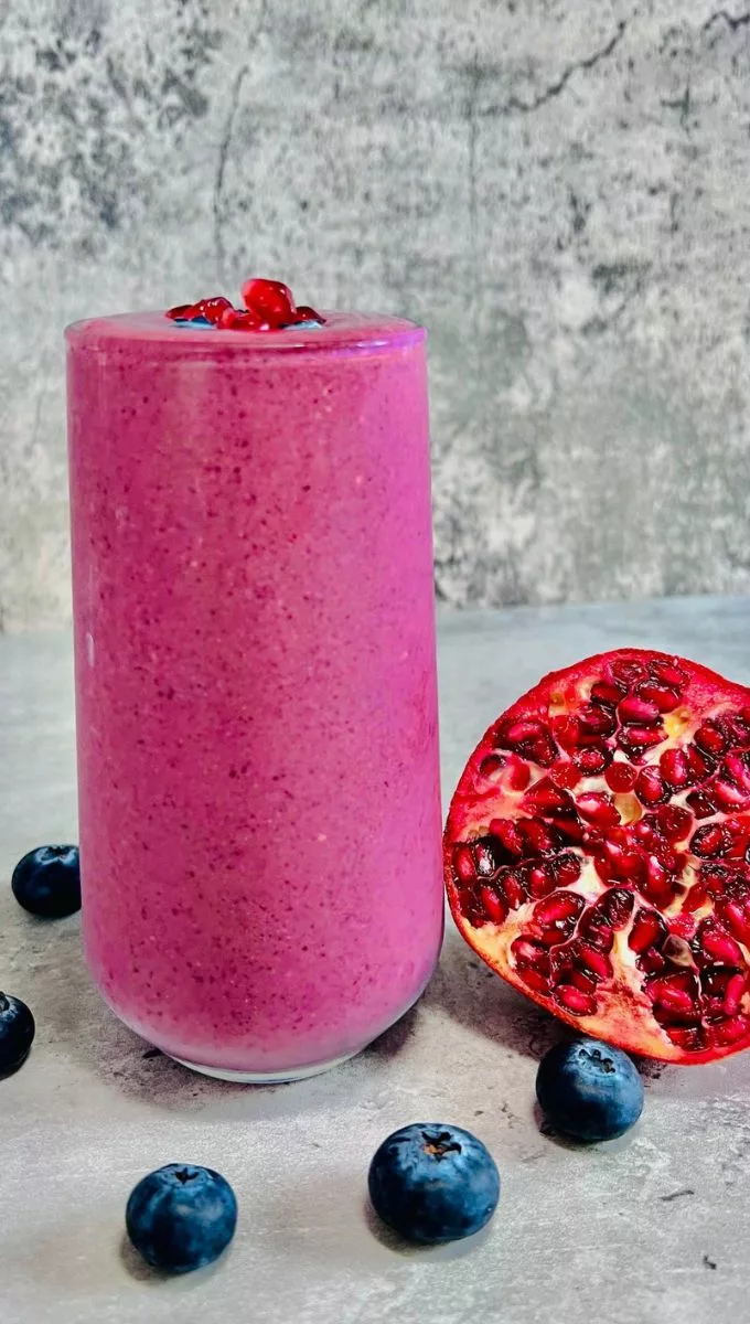 Blueberry Pomegranate Smoothie served in a tall thin glassed cup