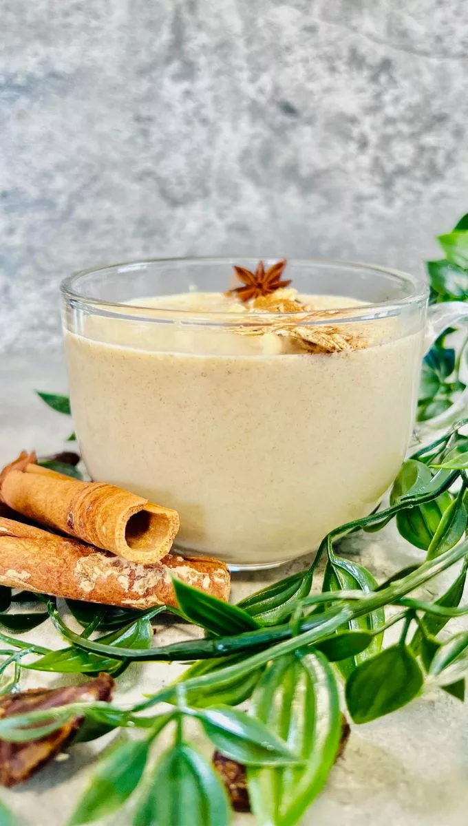 Overnight Oatmeal Smoothie surrounded by cinnamon sticks and greens