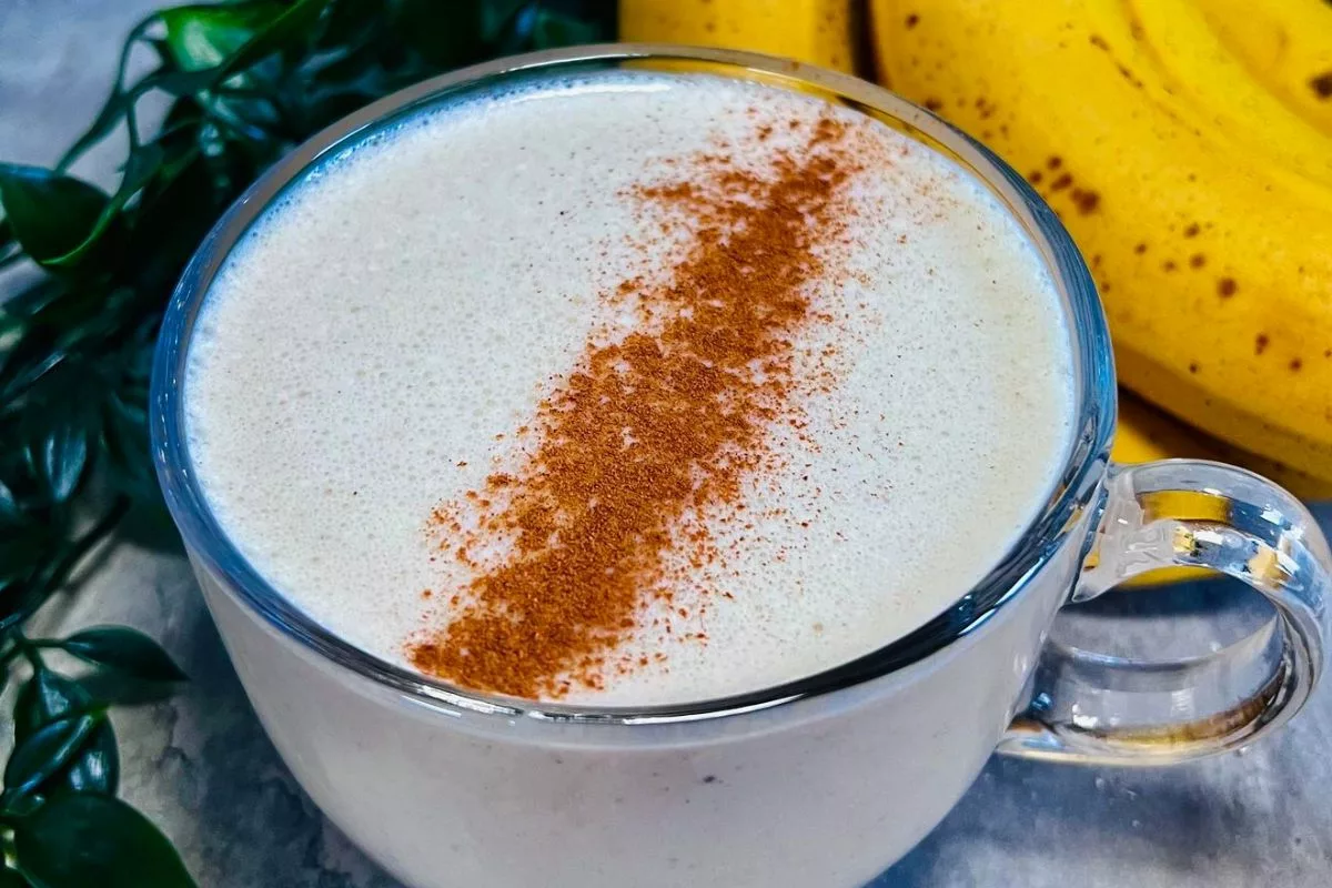 a close up shot of a glass cup filled with a weight loss banana smoothie