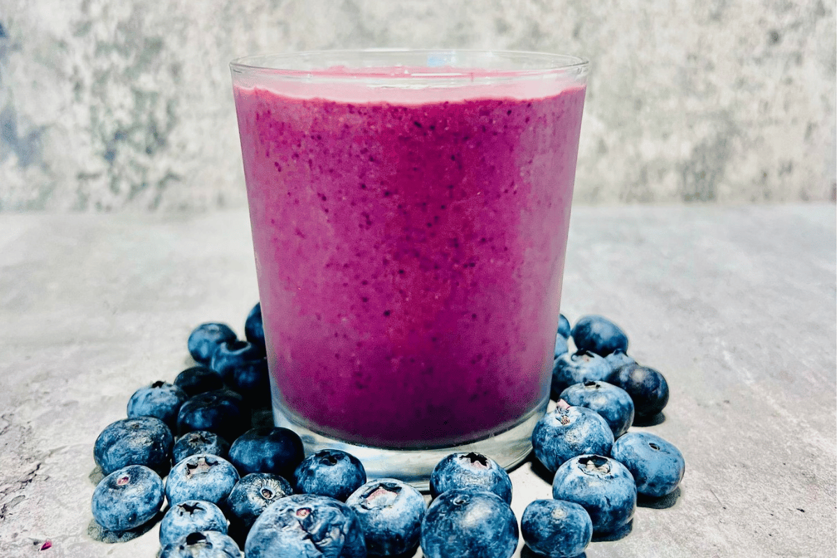 blueberry smoothie surrounded by fresh blueberries and hemp hearts