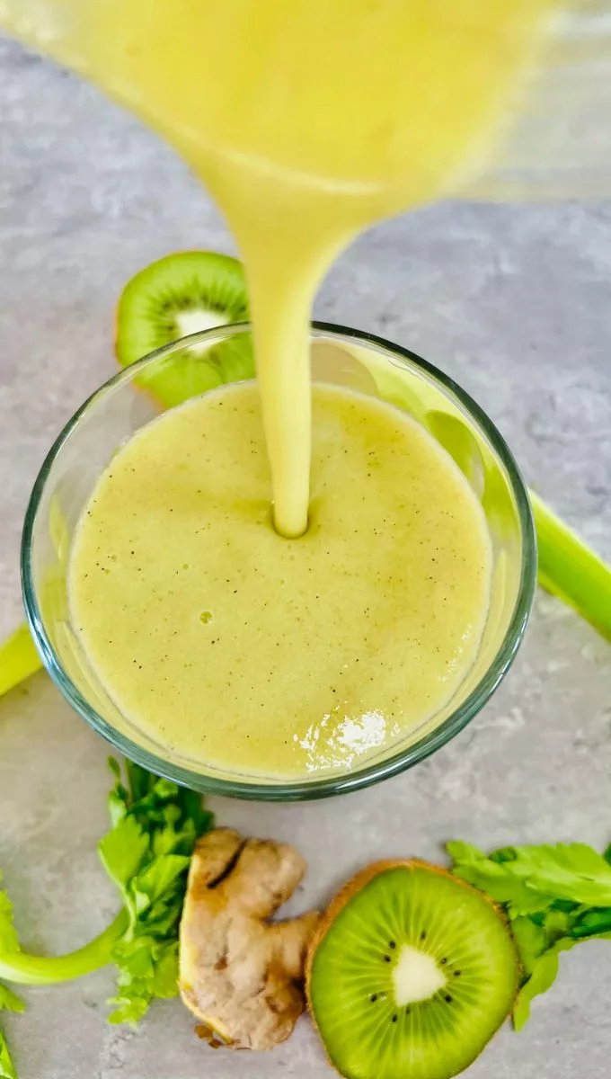 Celery Kiwi Ginger Smoothie being poured into a glass cup