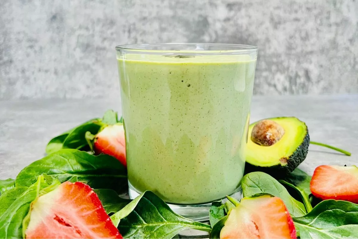 a side shot of a glass cup filled with a keto green smoothie made with cottage cheese avocado and spinach