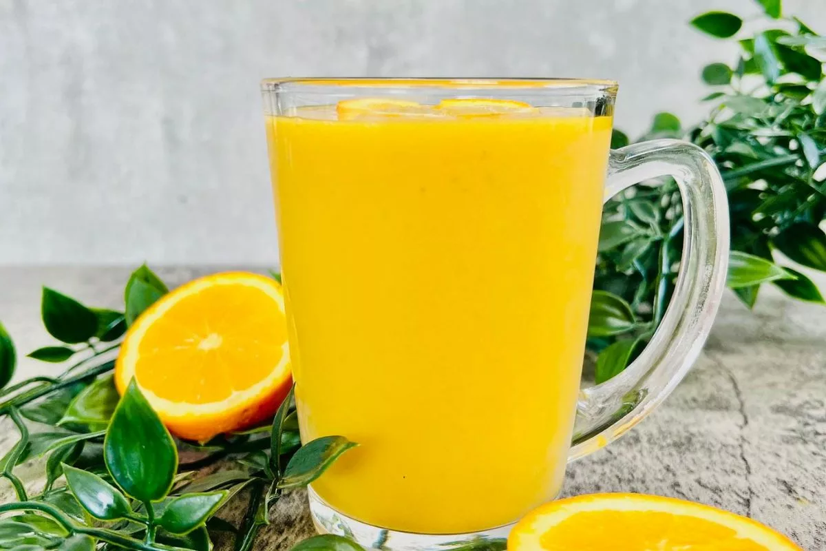 a tall glass cup filled with Orange Detox Smoothie