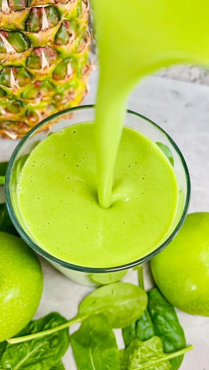 Green Apple Ginger Smoothie being poured into a glass cup