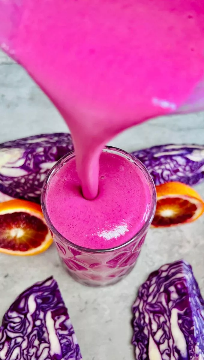 Purple Cabbage Smoothie being poured into a glass cup
