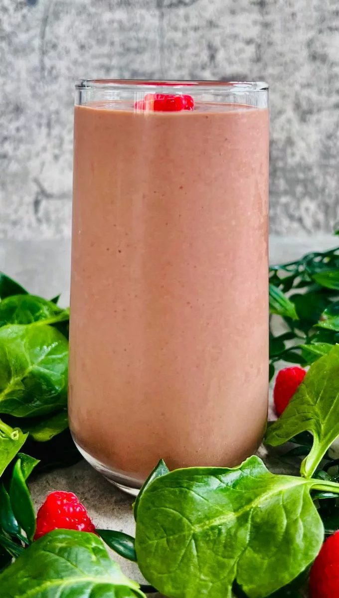 Raspberry Spinach Smoothie served in a tall thin glass cup