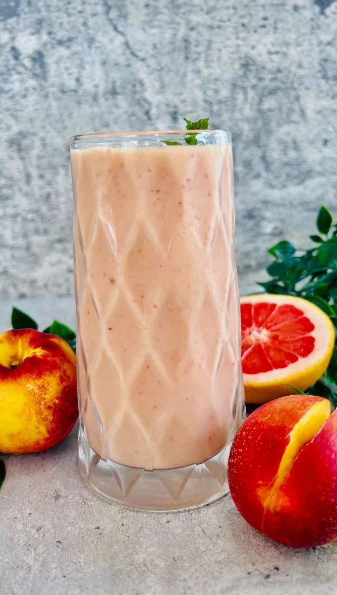 Smoothie With Nectarine served in a tall thick glass cup