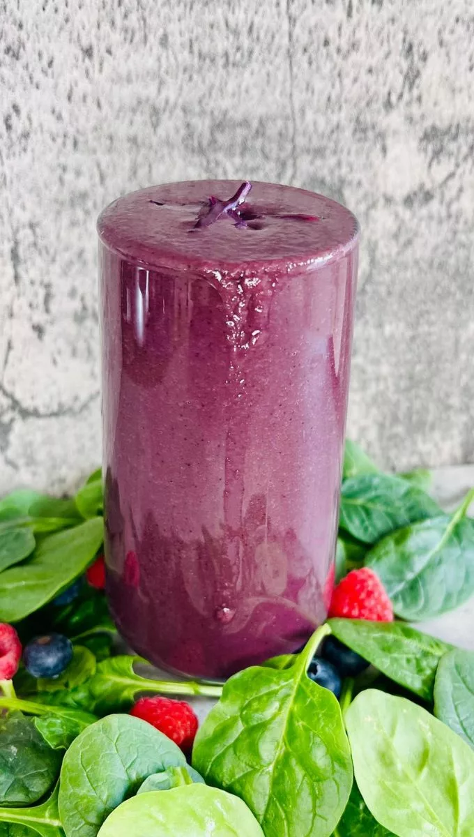 cabbage smoothie surrounded by berries and spinach
