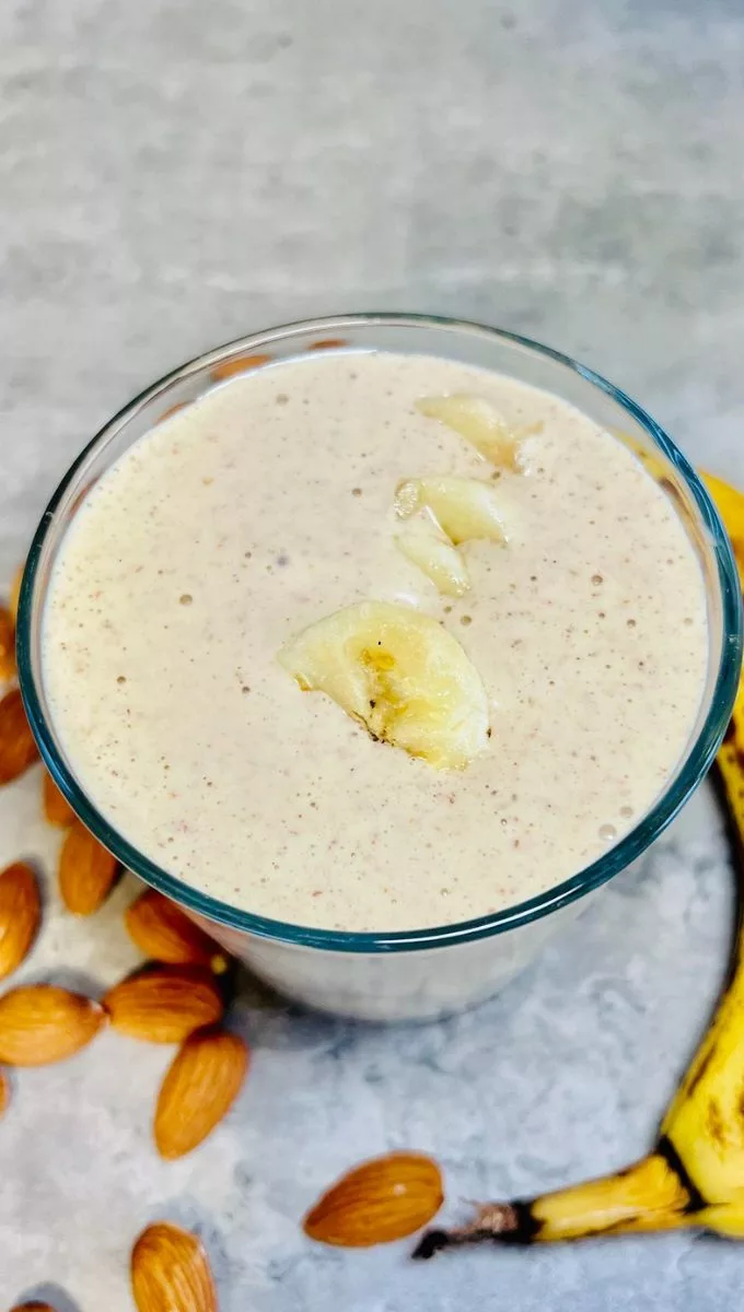 peanut butter banana smoothie glass cup topped with banana slices