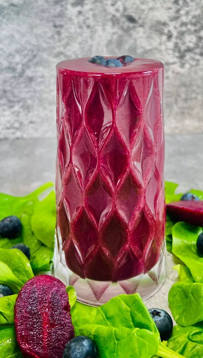 Blueberry Beetroot Smoothie surrounded by spinach blueberries and diced beet