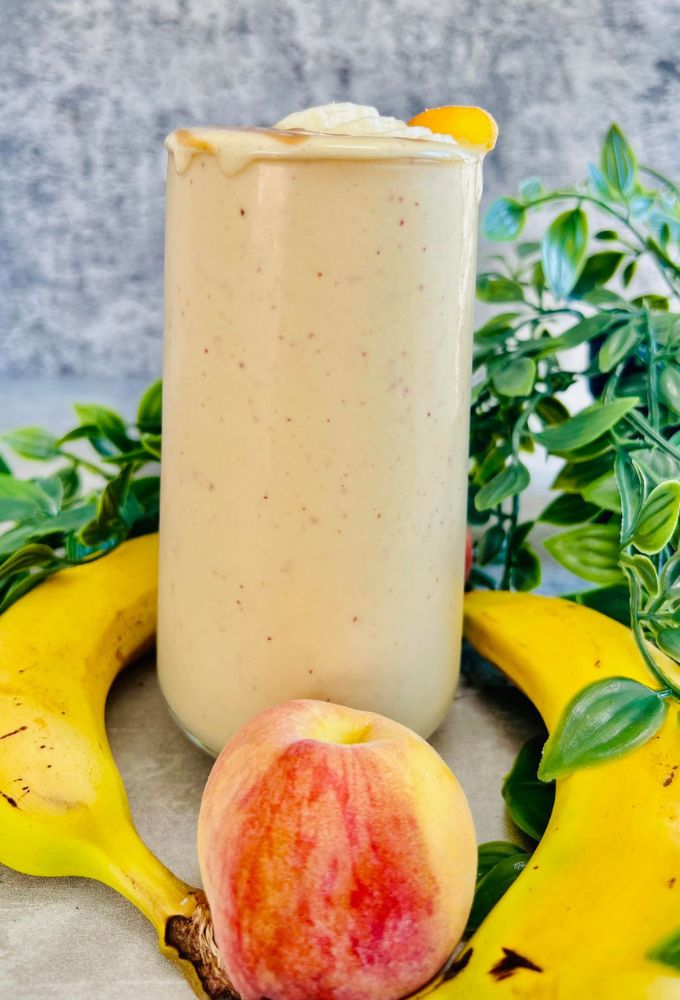Peach Banana Smoothie served in a tall thin glass cup